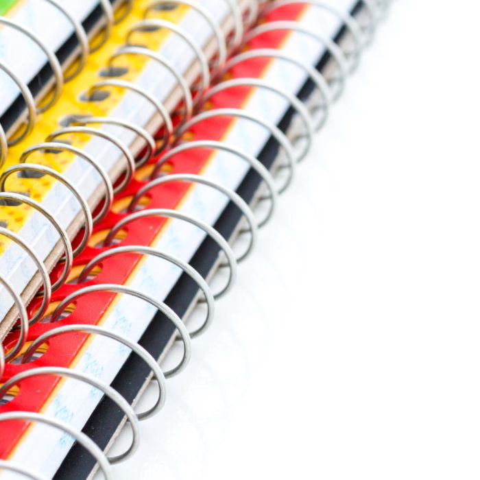 Multicolored spiral notebooks on a white background.